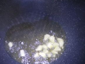 锅里倒入适量油加入大蒜爆香如图