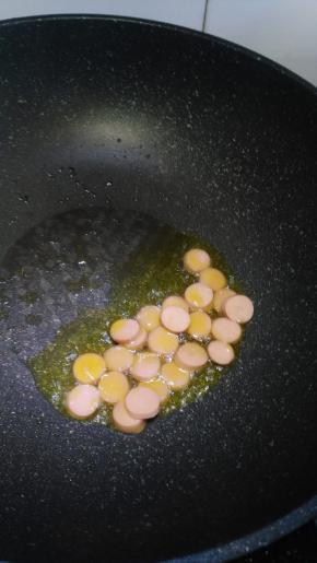 在锅内倒入适量的花生油，先炒香肠