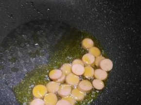 在锅内倒入适量的花生油，先炒香肠