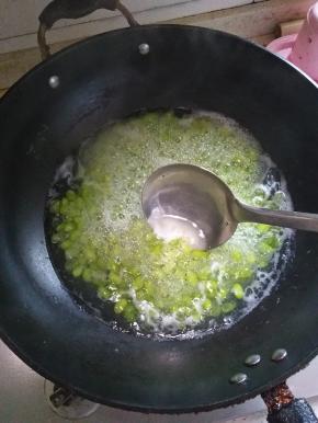 用勺子将上面的水泡沫和脱落的豆壳捞走，如图