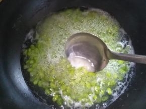 用勺子将上面的水泡沫和脱落的豆壳捞走，如图