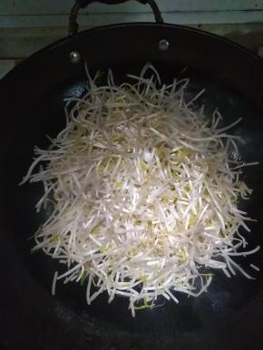 在锅内倒入适量的花生油，放入洗净的绿豆芽