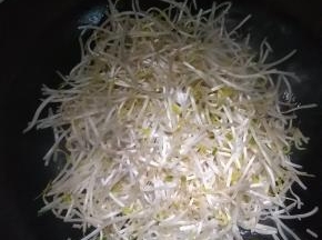 在锅内倒入适量的花生油，放入洗净的绿豆芽
