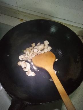 在锅内倒入适量的花生油，倒入切片的蘑菇，加少许盐翻炒