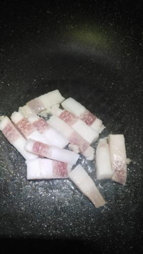 在锅内倒入适量的花生油，将肥肉放入锅里熬油