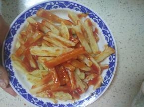 把准备好的番茄酱倒在薯条上面