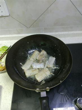 锅内放油，加热开小火，放入处理好的带鱼段，煎至两面微黄