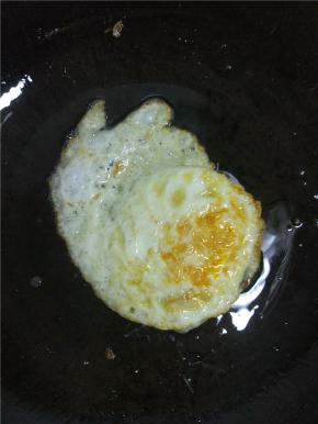 大约二十秒左右轻轻的晃动锅，鸡蛋凝固了在翻面，两面煎至微黄即可，喜欢吃糖心蛋的可以用筷子稍微探一下鸡蛋的软硬程度，两面煎黄之后，蛋黄内部还是软的就可以出锅了