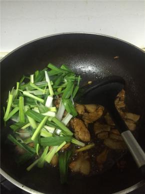 加入蒜苗，适量的盐和糖，翻炒均匀，如果喜欢汤汁可以加少量水