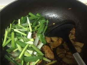 加入蒜苗，适量的盐和糖，翻炒均匀，如果喜欢汤汁可以加少量水