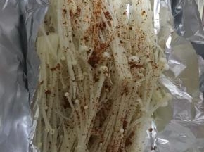 将炒好的肉末和汤汁一并浇在金针菇上，包好放入烤箱