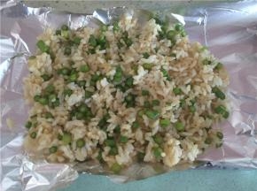 在烤盘上铺上锡纸，将饭放入锡纸中，然后包起来