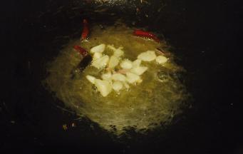 大火红油八成热，先将干辣椒放入炝锅，再将切好的算入锅爆香；