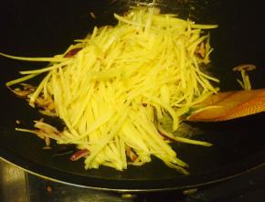 当土豆丝颜色呈金黄状时，沿锅边倒入陈醋，翻炒两下后放盐出锅