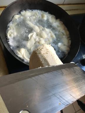 水浇沸腾后用薄片菜刀削入沸水内