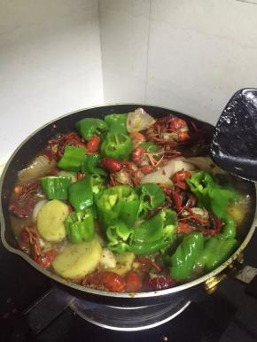 倒入一瓶啤酒，放入青椒，放入小龙虾料，依口味适当加入调味料，翻炒5-8分钟。