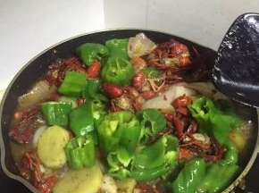 倒入一瓶啤酒，放入青椒，放入小龙虾料，依口味适当加入调味料，翻炒5-8分钟。