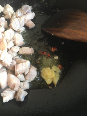 先入五花肉炒干水分，拨至锅的一侧，加入油，放姜片，八角及白糖炒糖色