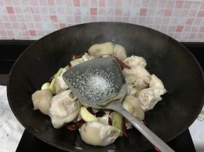 倒猪手进来翻炒，猪手全部裹上油汁后加一点点白糖，继续不断翻炒，可以稍微久一点，