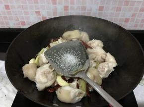 倒猪手进来翻炒，猪手全部裹上油汁后加一点点白糖，继续不断翻炒，可以稍微久一点，