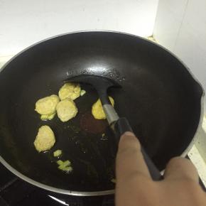 倒入炸鱼丸，翻炒1-2分钟，再加入少量盐