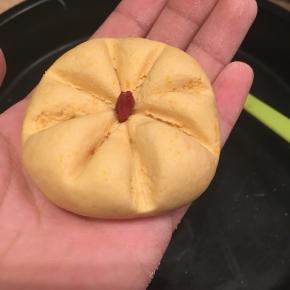 取一小团南瓜面团，用牙签或塑料刮刀，压出南瓜的条纹，中间加一粒枸杞做南瓜饼