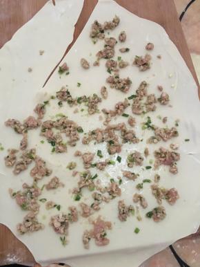 搅拌好的肉摊在擀好圆形的面饼上（摊3/4的圆）划一刀