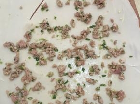 搅拌好的肉摊在擀好圆形的面饼上（摊3/4的圆）划一刀
