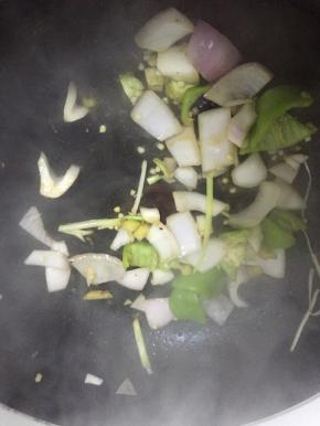 倒入洋葱和青椒，翻炒1-2分钟，至变软，再加入少量盐