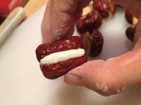 取一小块糯米，夹入红枣中