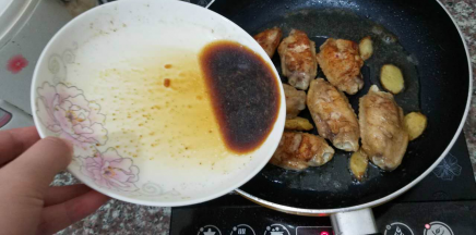 两次翻面煎黄鸡翅之后，将之前剩下的腌汁倒入锅中，焖透鸡肉