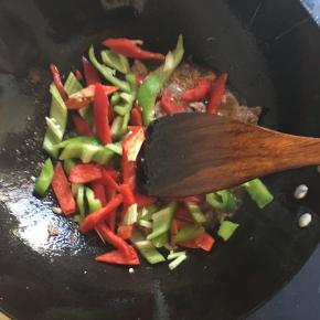 变色后加入双椒翻炒3分钟左右加入1个半茶匙料酒