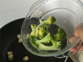 2分钟左右后，加入西兰花，翻炒1-2分钟