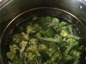 西兰花掰开，洗干净用水泡5分钟，切开，放入锅子里煮3-5分钟