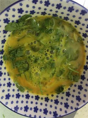 将香菜末拌入鸡蛋里，拌匀