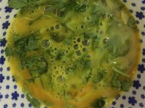 将香菜末拌入鸡蛋里，拌匀
