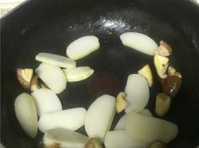 把年糕切片，也可以直接买片状年糕，待香菇变软后，加入年糕片，翻炒1-2分钟