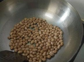 将花生米凉油下锅，小火翻炒至花生米变得有点微黄