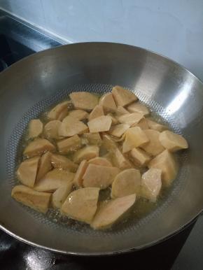 将地瓜炸完盛盘，在空锅内倒入少许油，放俩大勺白糖