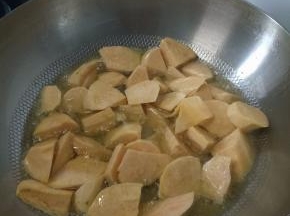 将地瓜炸完盛盘，在空锅内倒入少许油，放俩大勺白糖