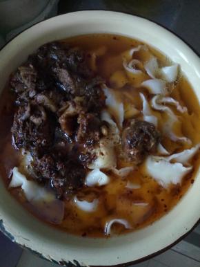 在把牛肉放入刚才煮好的面中