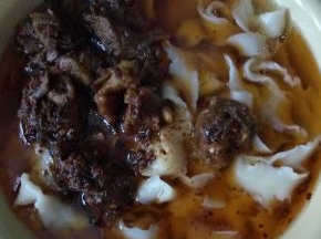 在把牛肉放入刚才煮好的面中