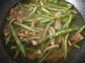 再加入洗好豆角加入锅内，翻炒豆角至青绿色加入水末过豆角大火等到水开。