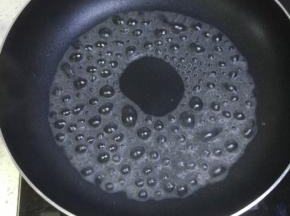 不粘锅里面放能覆盖一平锅底的水，烧开