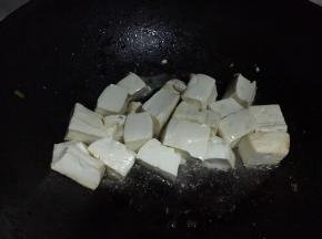 轻轻翻动部分豆腐，可以看到贴锅的一面已有金黄色