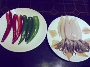 一斤鱿鱼，洗干净，去皮，头和触角分开；青红椒去籽洗净，姜蒜、洋葱适量切成末