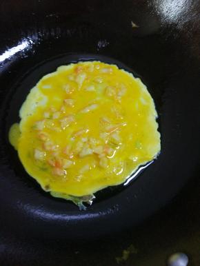 锅内放少量油，转动锅，均匀涂满锅底，烧热，倒入蛋液