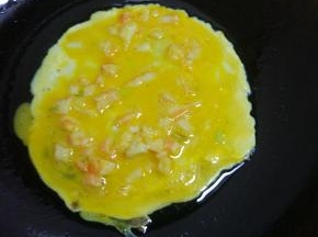 锅内放少量油，转动锅，均匀涂满锅底，烧热，倒入蛋液