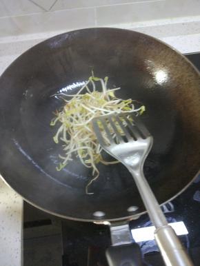 锅内放热油，放入葱姜蒜爆香。放入豆芽