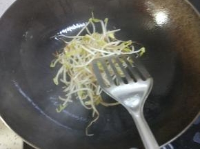 锅内放热油，放入葱姜蒜爆香。放入豆芽